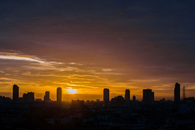 Silhouette buildings against sky during sunset