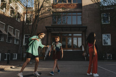 Girls spending leisure time while playing outside campus