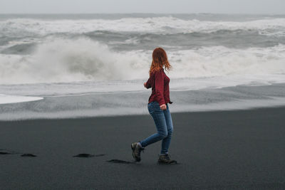 Young tourist walking along empty iceland beach scenic photography