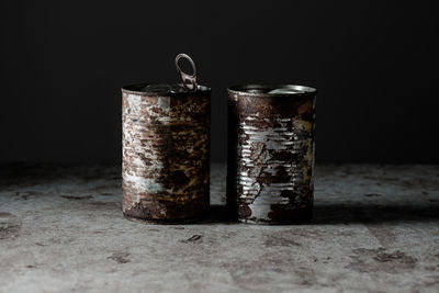 Close-up of old jar against black background