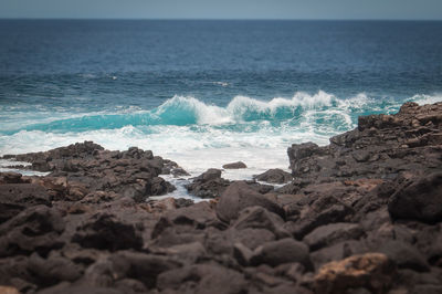Tilt shift effect of oceanic waves against the boca de abaco volcanic rocks coast, lanzarote
