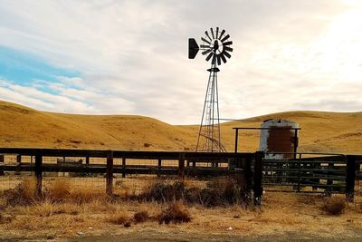 Windmill on field against sky