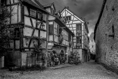 Footpath amidst old buildings against sky