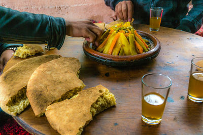 Cropped image of people eating food on table