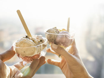 Man and woman holds plastic bowls with ice-cream. cold dessert. gelato with spoons. romantic date.