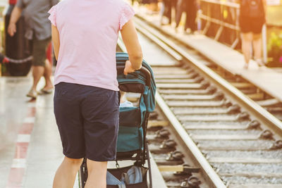 Rear view of people walking on railroad station