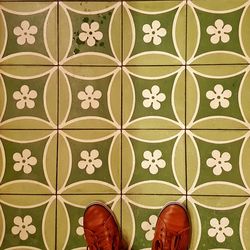 Low section of person standing on tiled floor