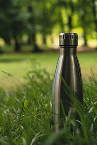 Water bottle. reusable steel thermo water bottle on green grass. sustainable lifestyle. plastic free