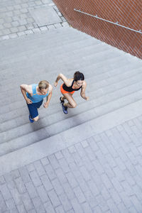 High angle view of fit couple running on steps outdoors