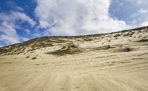 Sand dunes in desert against sky