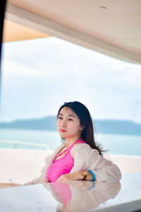 Portrait of young woman sitting at beach