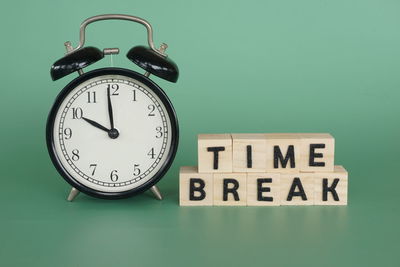 Close-up of clock on green background