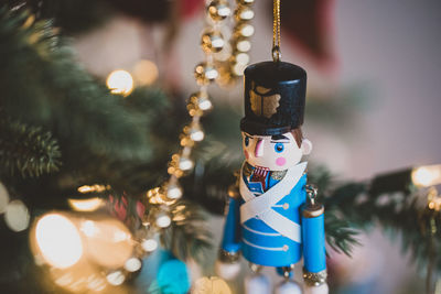 Close up of nutcracker ornament hanging on a christmas tree.