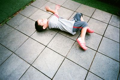 High angle view of baby sleeping on tiled floor