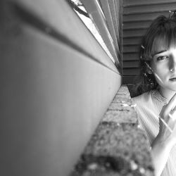 Portrait of young woman against building