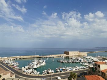 High angle view of harbor by buildings against sky