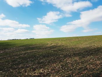 Scenic view of field against cloudy sky