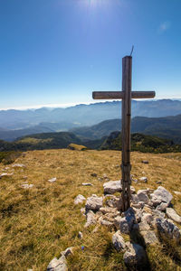 Cross on land against sky