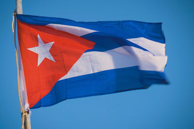 Cuba flag waving in the wind against deep blue sky.