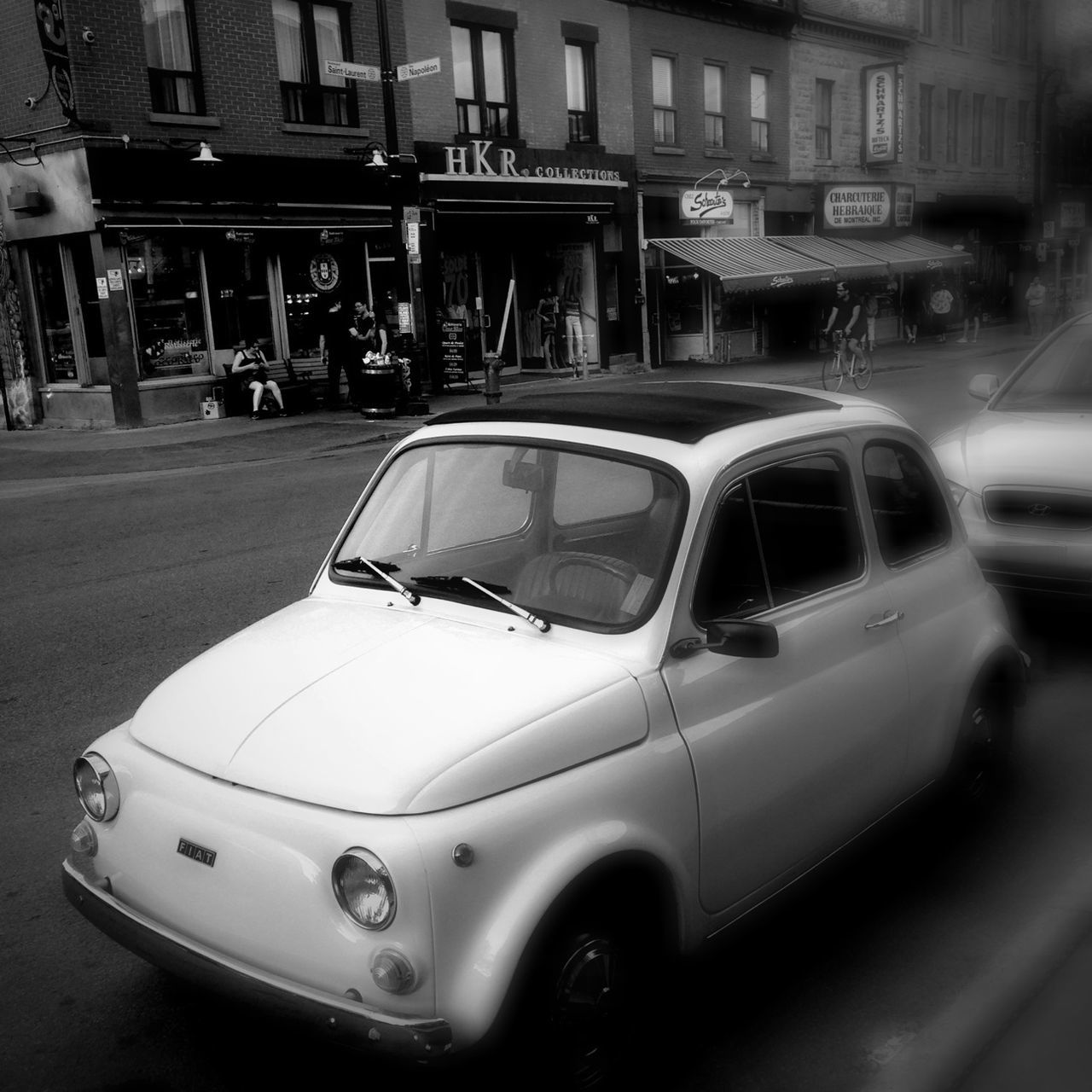 transportation, mode of transport, car, land vehicle, travel, building exterior, street, architecture, stationary, city, built structure, vehicle, in a row, on the move, window, day, reflection, outdoors, no people, road