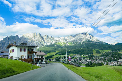 Road by mountains against sky