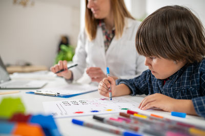 Mother drawing on book at home