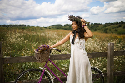 Asian woman with retro bike in flower field