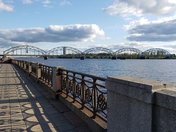 Bridge over river in city against sky