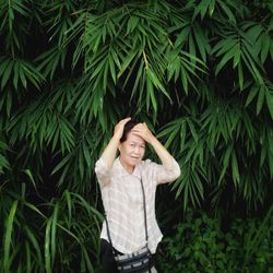 Portrait of woman standing against trees