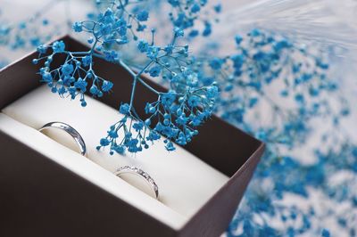 Close-up of wedding ring with artificial flower in box