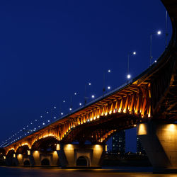 Low angle view of illuminated bridge against sky at night