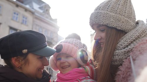 Lesbian couple with baby standing outdoors