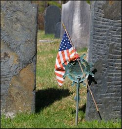 Woman with umbrella flag in cemetery