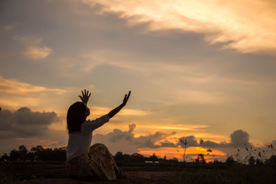 Silhouette woman standing by sea against sky during sunset