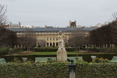 Fountain in garden against buildings