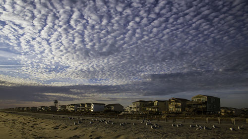 Panoramic view of people on beach against sky