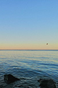 Scenic view of sea against clear sky during sunset