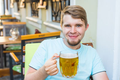 Portrait of a young man drinking glasses outdoors