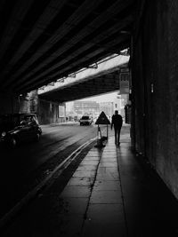 Man walking under bridge