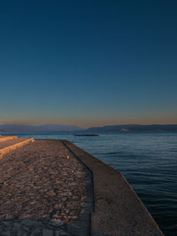 Scenic view of sea against clear blue sky during sunset