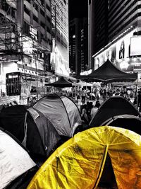 Rear view of people on street amidst buildings in city