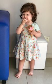 Portrait of cute girl eating ice cream at home