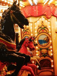 Low angle view of illuminated carousel in amusement park