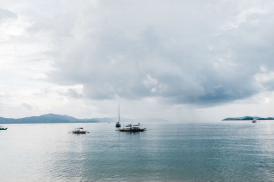 Sailboats in sea against sky