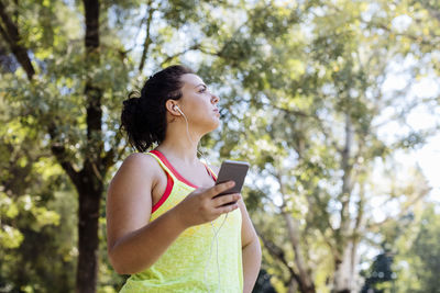 Young sporty woman using smartphone in park