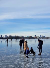 People enjoying in water against sky