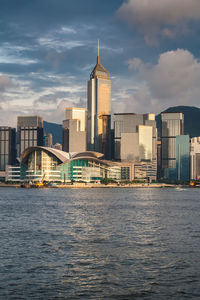 View of buildings at waterfront against cloudy sky