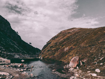 Scenic view of river by mountains against sky