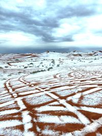 Scenic view of snow covered beach against sky