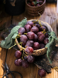 Red grape fruits in bowl on wooden table